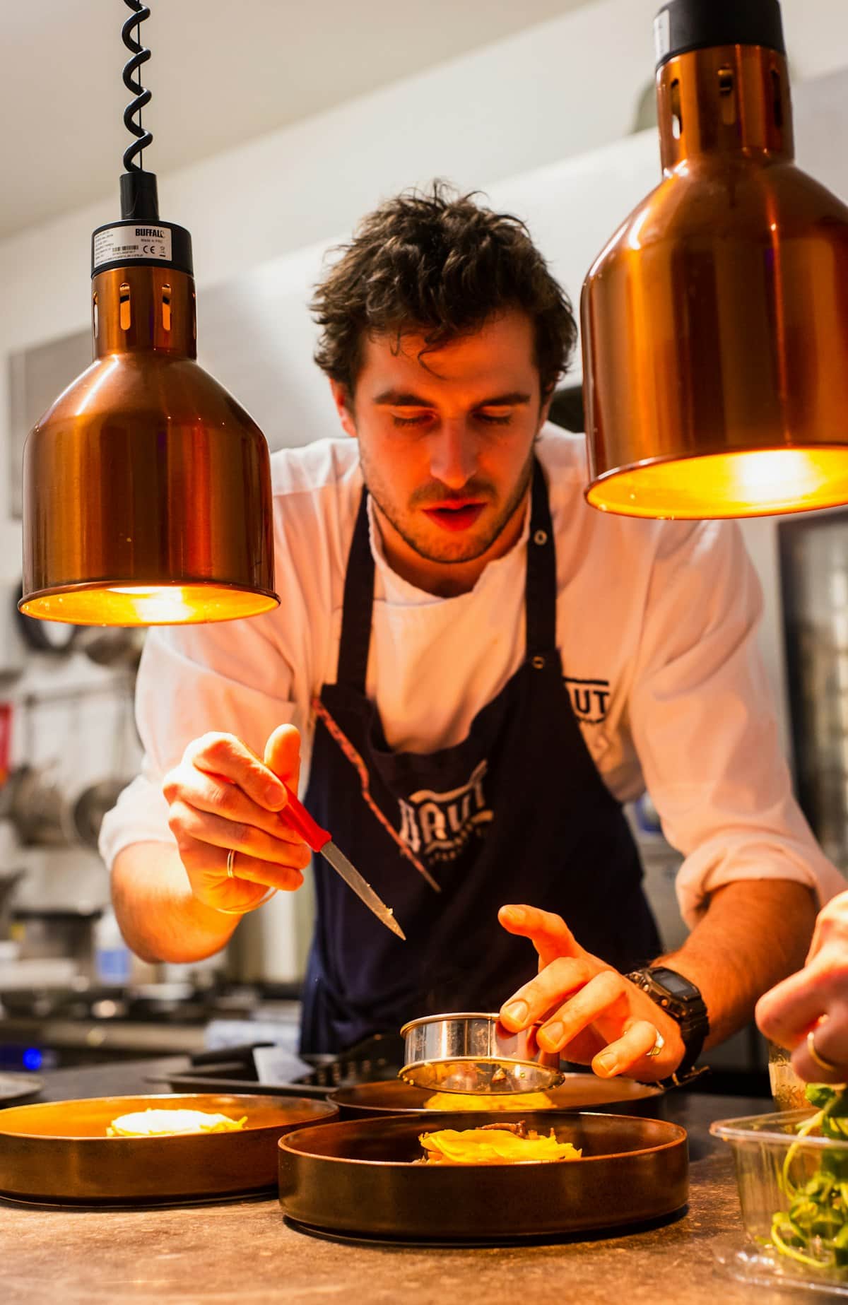 Chef plating dishes in the open kitchen